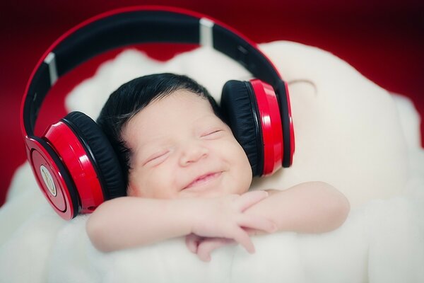 Lindo bebé escuchando música en auriculares