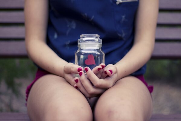 A girl holds a jar with a paper heart