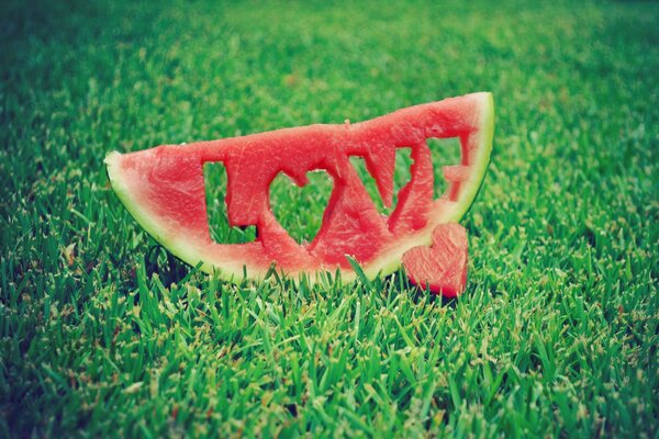 Watermelon slice with an inscription on the lawn