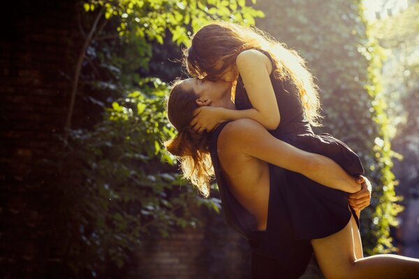 Couple kissing on the background of trees