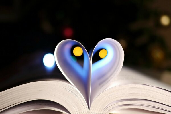 An open book with folded pages in the form of a heart