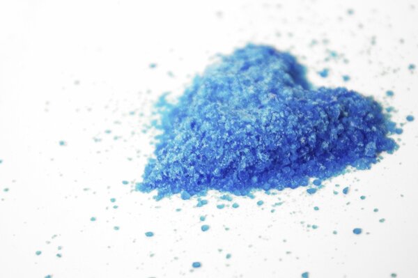 Blaues Herz aus Krümel liegt auf weißem Hintergrund