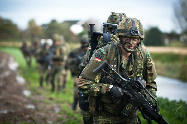 Des soldats allemands en camouflage marchent avec des fusils d assaut