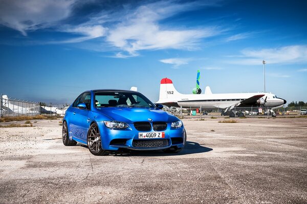 BMW bleu se dresse sur fond d avion