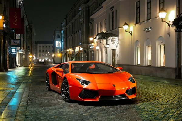 Lamborghini naranja en la ciudad de la noche