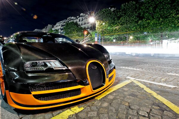 Bugatti tuneado negro en el pavimento nocturno