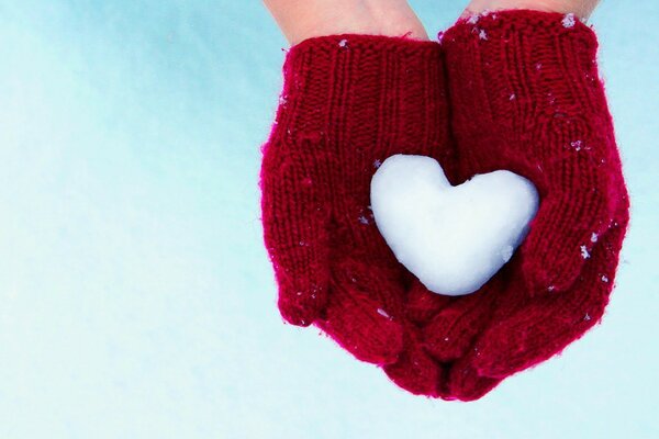 Snow heart in red knitted mittens