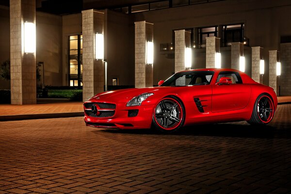 Rosso Mercedes amg sls su uno sfondo di lampioni