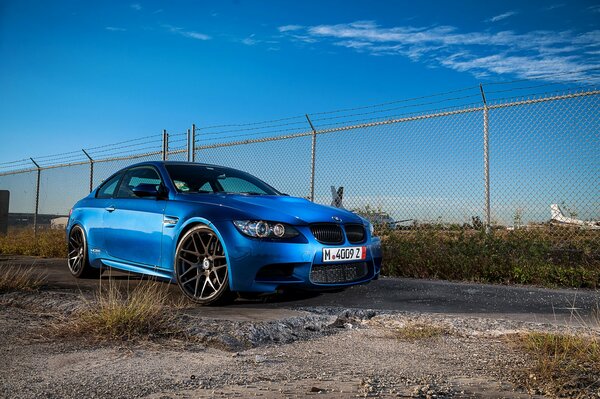 Ein blauer, himmelblauer BMW m3 wurde in der Nähe einer Leitplanke versteckt