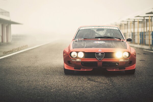 Alfa romeo rojo con faros encendidos