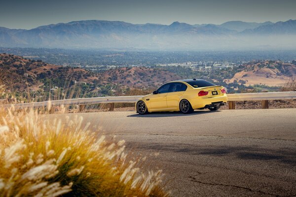 BMW amarillo en la pista, y lejos de la montaña, la ciudad