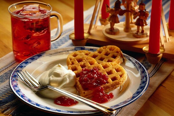 Desayuno té con gofres y mermelada en un plato