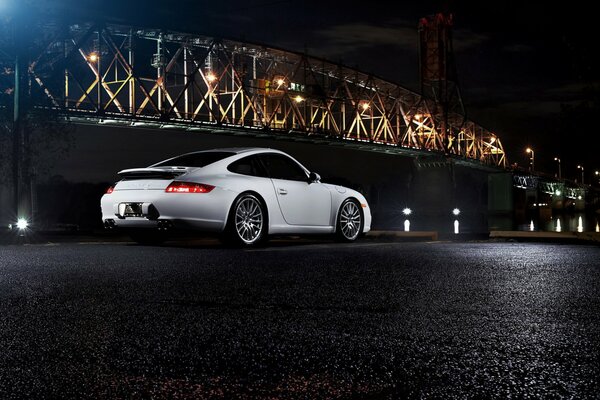 White Porsche on the background of the bridge, at night