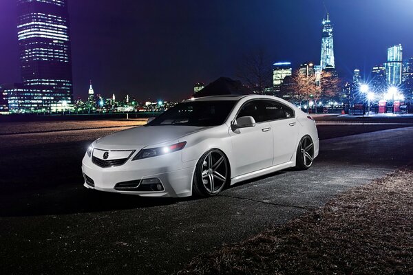 White acura car in the middle of the night city