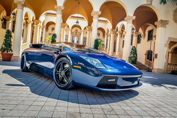 Supercar blu lucido vicino al Palazzo collona