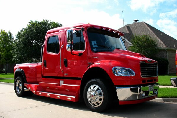 A beautiful red truck is standing on the road