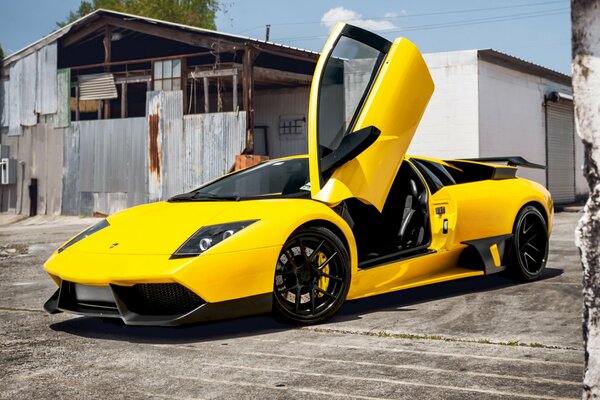 Lamborghini Murcielago giallo contro un vecchio fienile