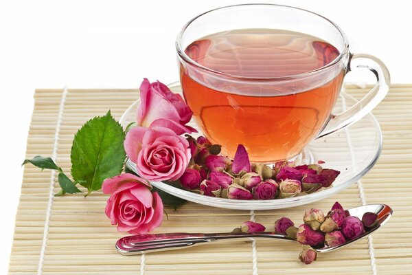 Tea in a glass cup on a background of roses