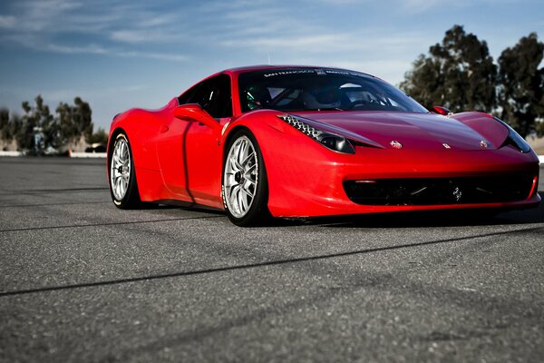 Ferrari rojo en un camino soleado