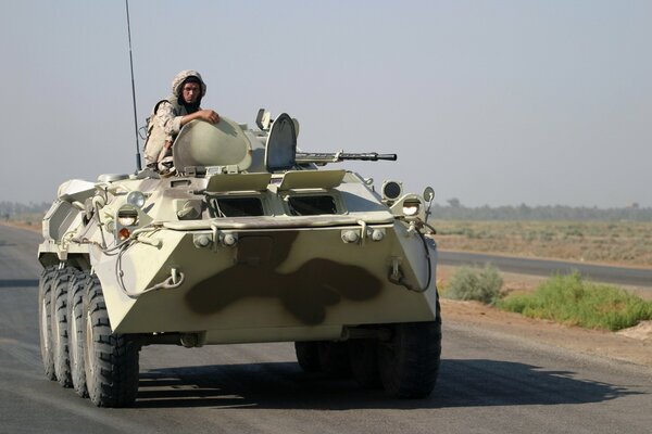 Soldado en camuflaje montando en un tanque en la carretera