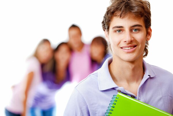 A young guy with a notebook against the background of other people