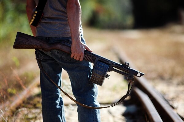 A man with a gun on the background of a railway