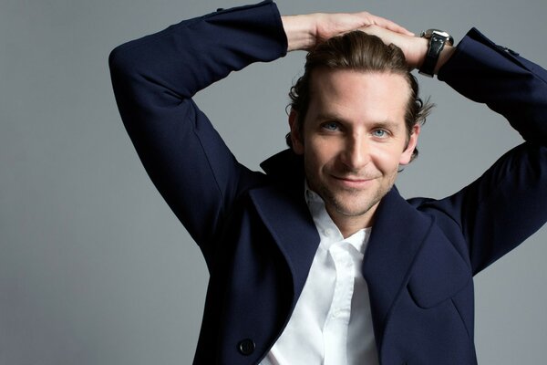 El actor Bradley Cooper sobre un fondo gris