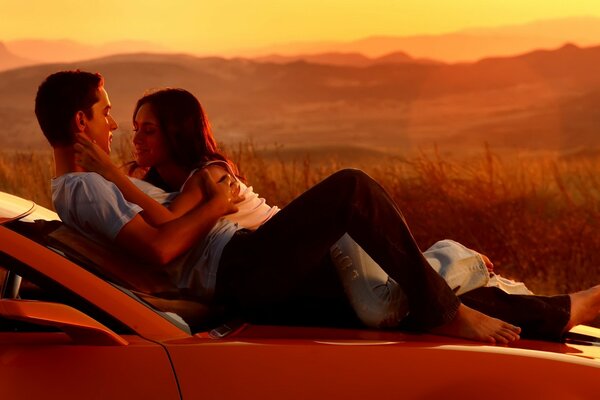 Pareja enamorada al atardecer en coche