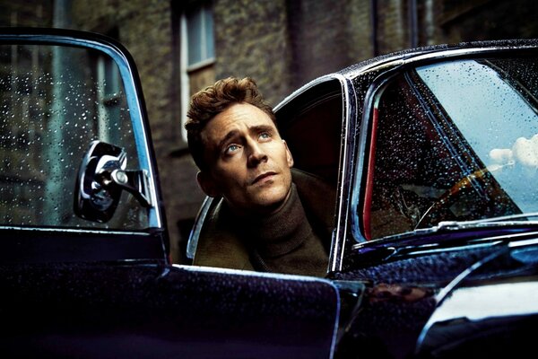 Actor Tom Hiddleston leans out of the car