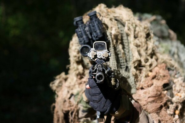 A sniper in a makeshift takes aim at point-blank range