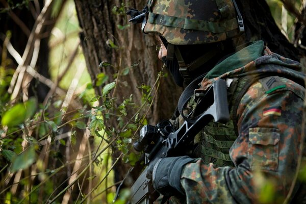 Soldat mit Waffen im Wald