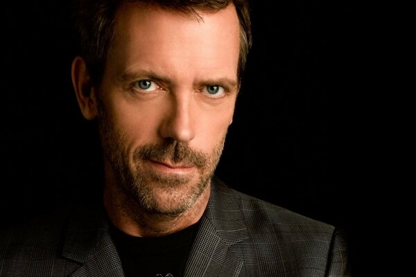 Actor Hugh Laurie on a black background