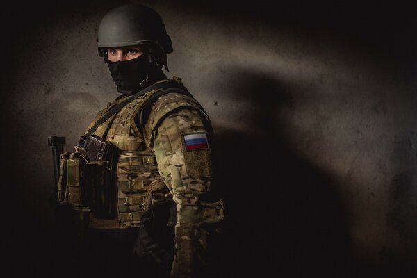 A soldier of the Ministry of Internal Affairs in a helmet on a dark background