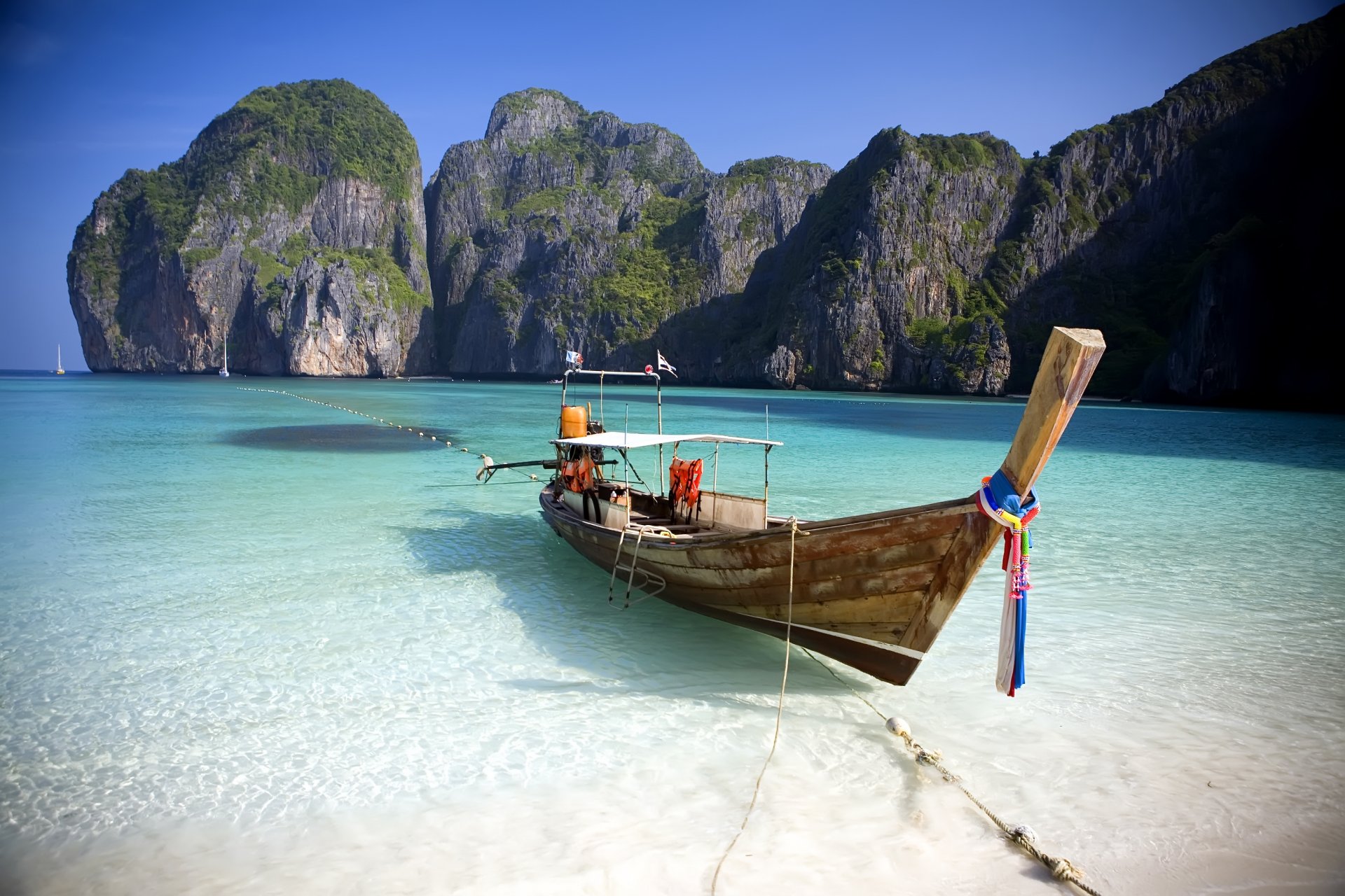 island shore beach rocks ocean water azure boat