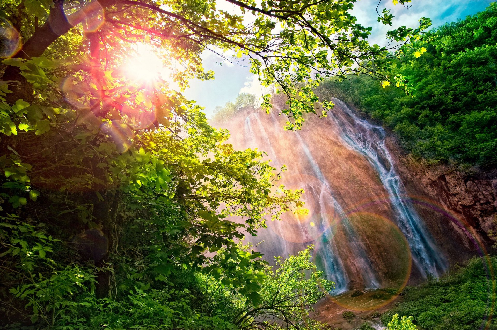 cascada deslumbrante sol resplandor espectro arco iris montañas naturaleza paisaje