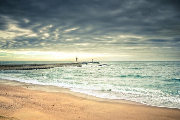 Spiaggia di sabbia con fari sul mare