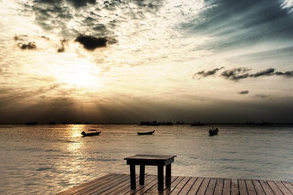 Landscape with boats and pier against the sky