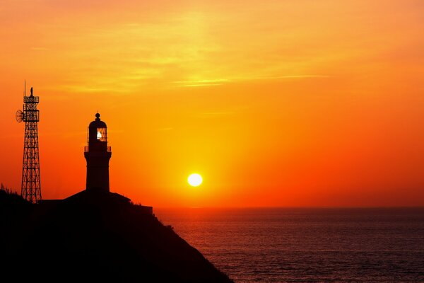 Phare sur fond de coucher de soleil dans l océan