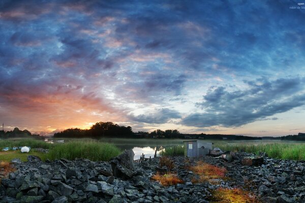 Beautiful sunset over the lake and field