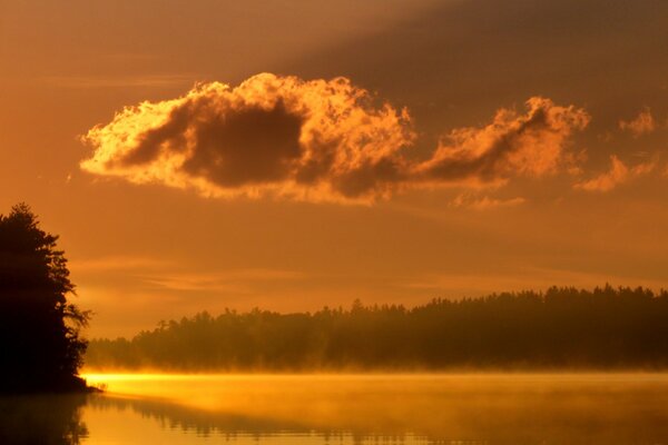 Orange Sonnenuntergang am See. Nebel über dem See