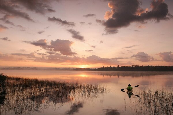 Pescador en un barco al atardecer