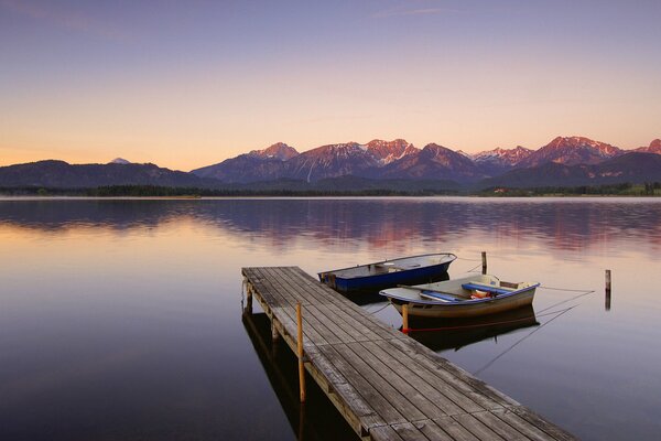 Ein See im Morgengrauen. Liegeplatz und Boote