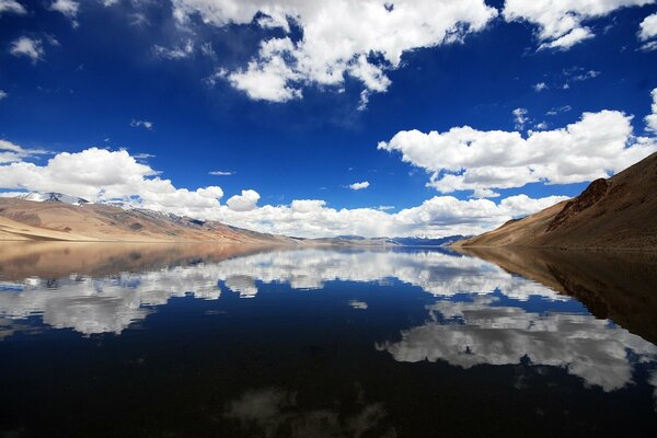 The mirrored surface of the lake surrounded by mountains