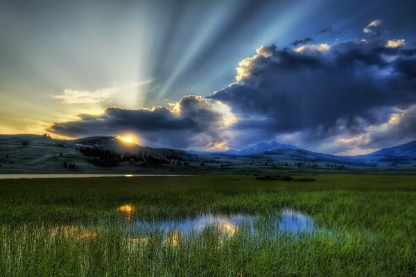 Les rayons du soleil couchant sur fond de nuages sombres