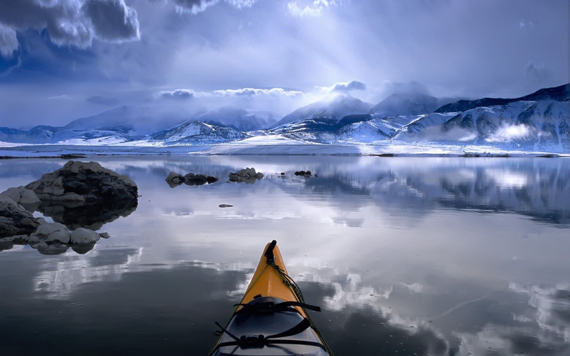 barco montañas río nubes