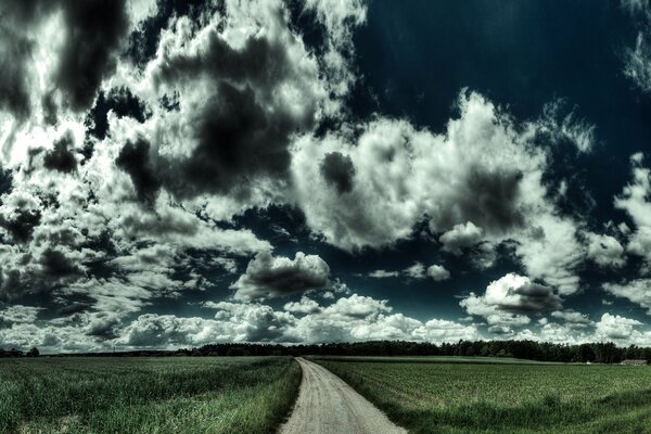 Impressive clouds over the field and road