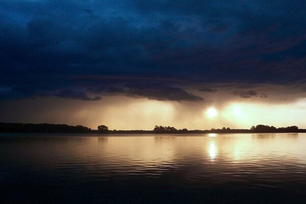 Ein finsterer Sonnenuntergang. Wolken spiegeln sich im Meer wider