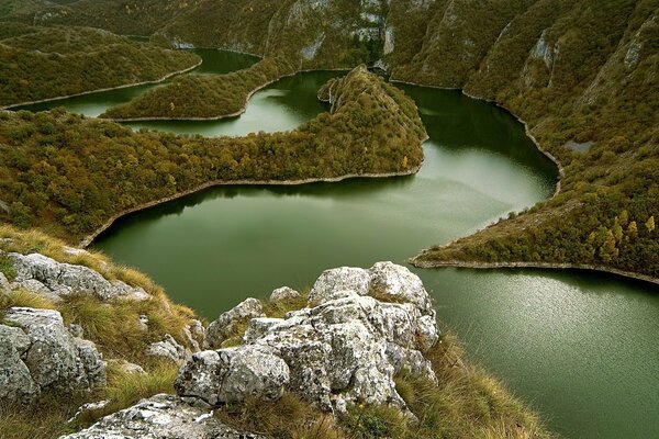 Green river between wooded mountains