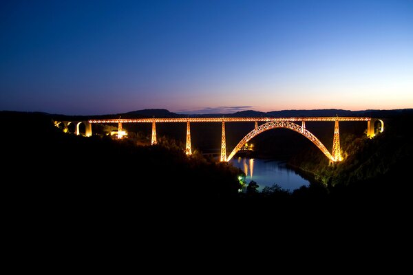 El puente entero arde con luces brillantes sobre el río