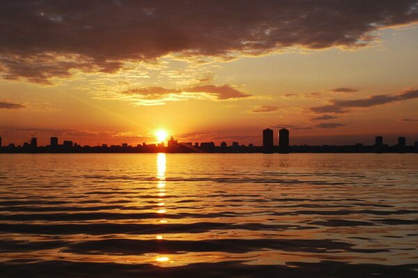 Una gran ciudad en medio de una puesta de sol ardiente